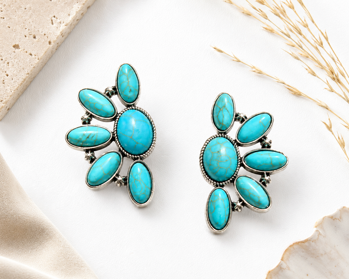 Turquoise earrings on a light background with natural elements