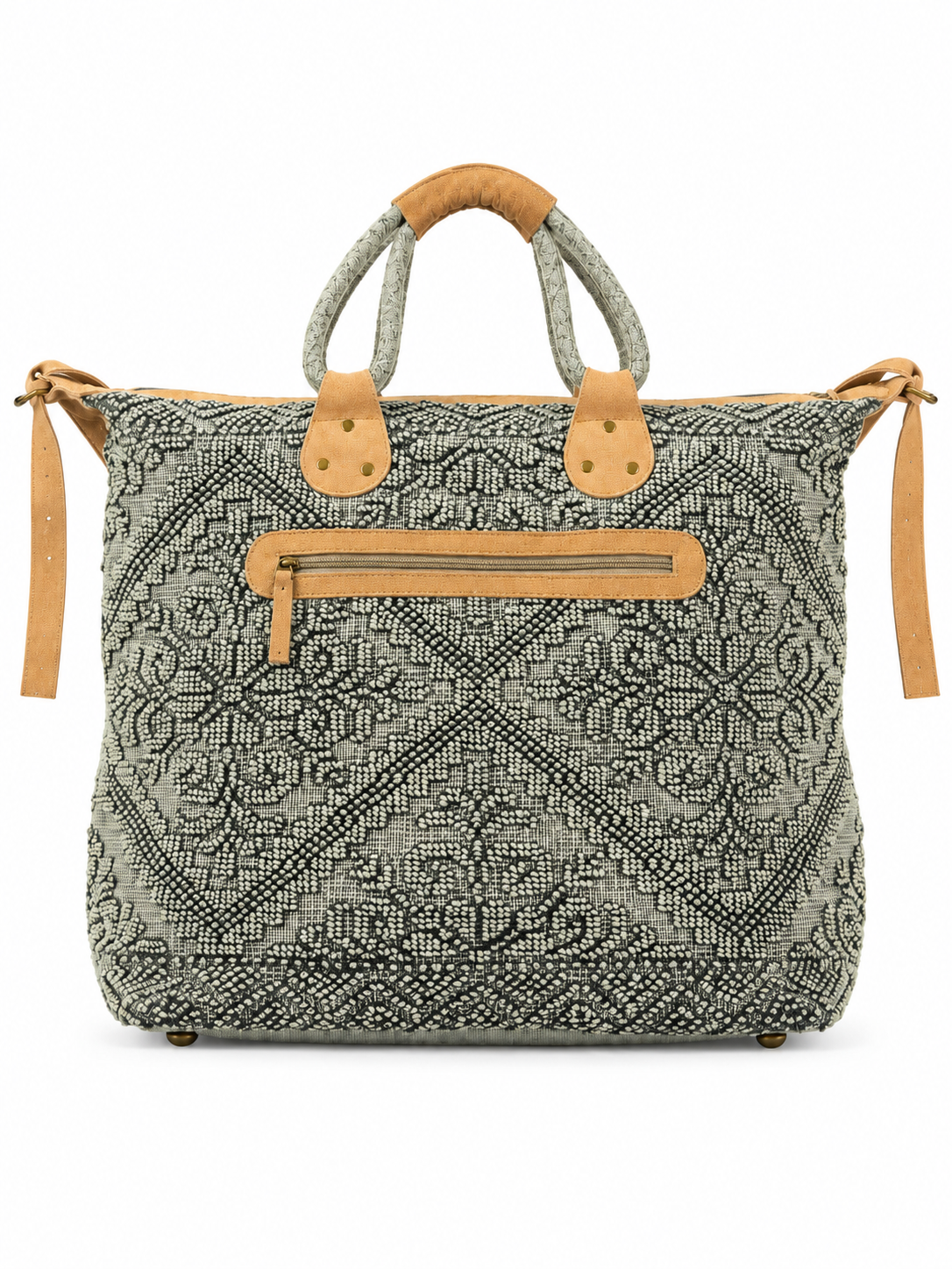 Back view of a black and ivory paisley-patterned tote bag with textured fabric, tan leather accents, double wrapped handles, brass-tone hardware, and an exterior zippered pocket against a white background.