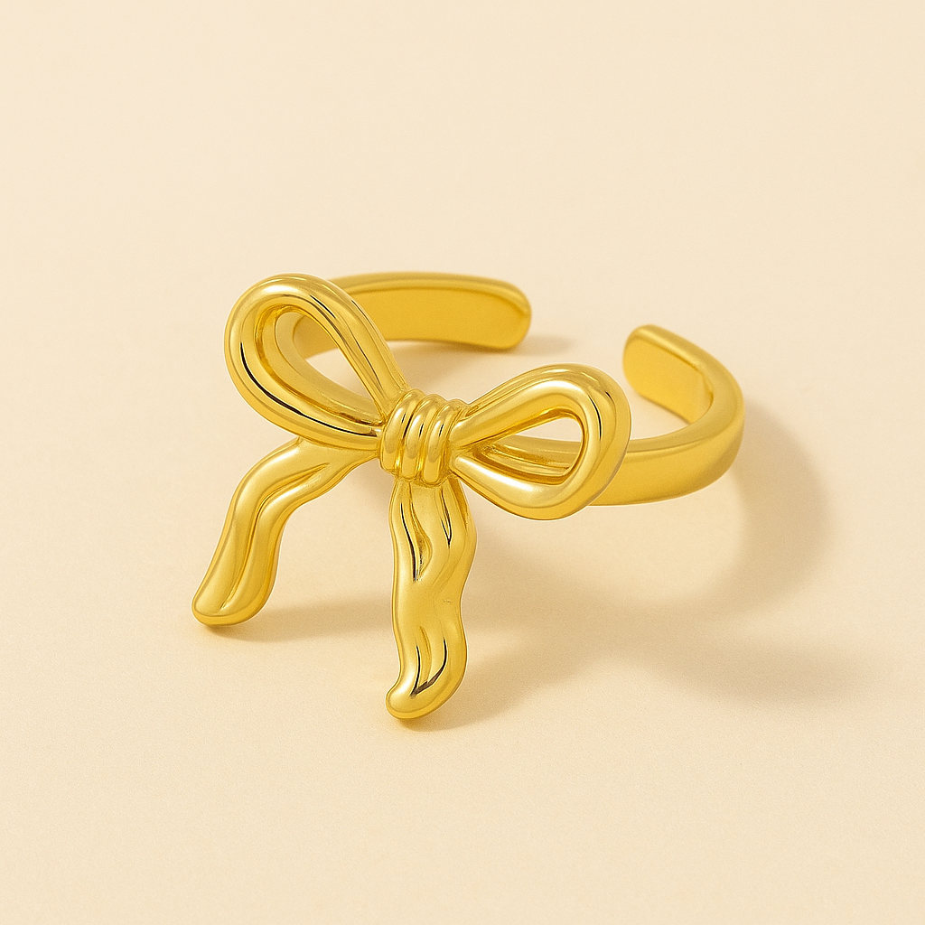 Gold bow-shaped bracelet on a beige background