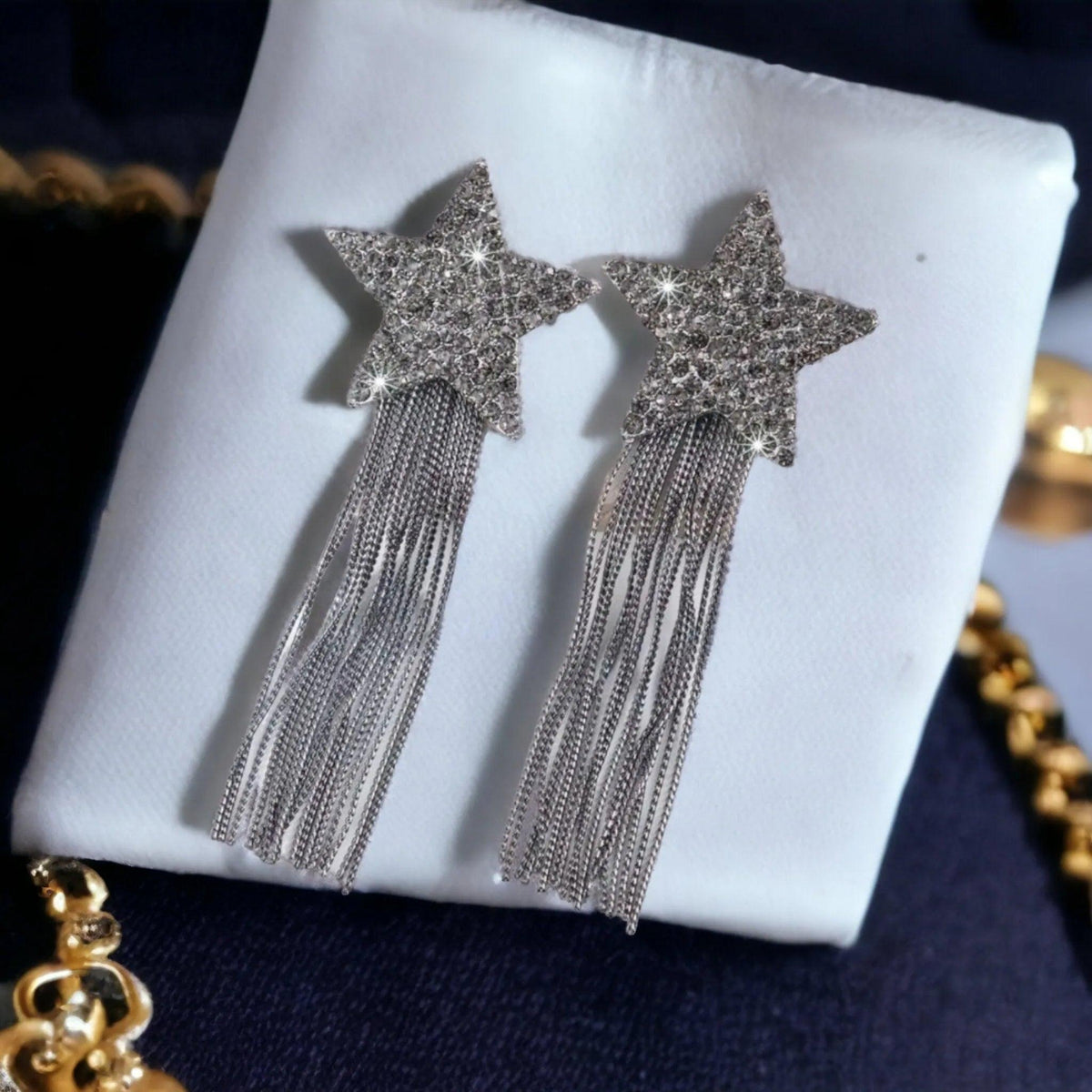 Star-shaped earrings with tassels on a white cloth