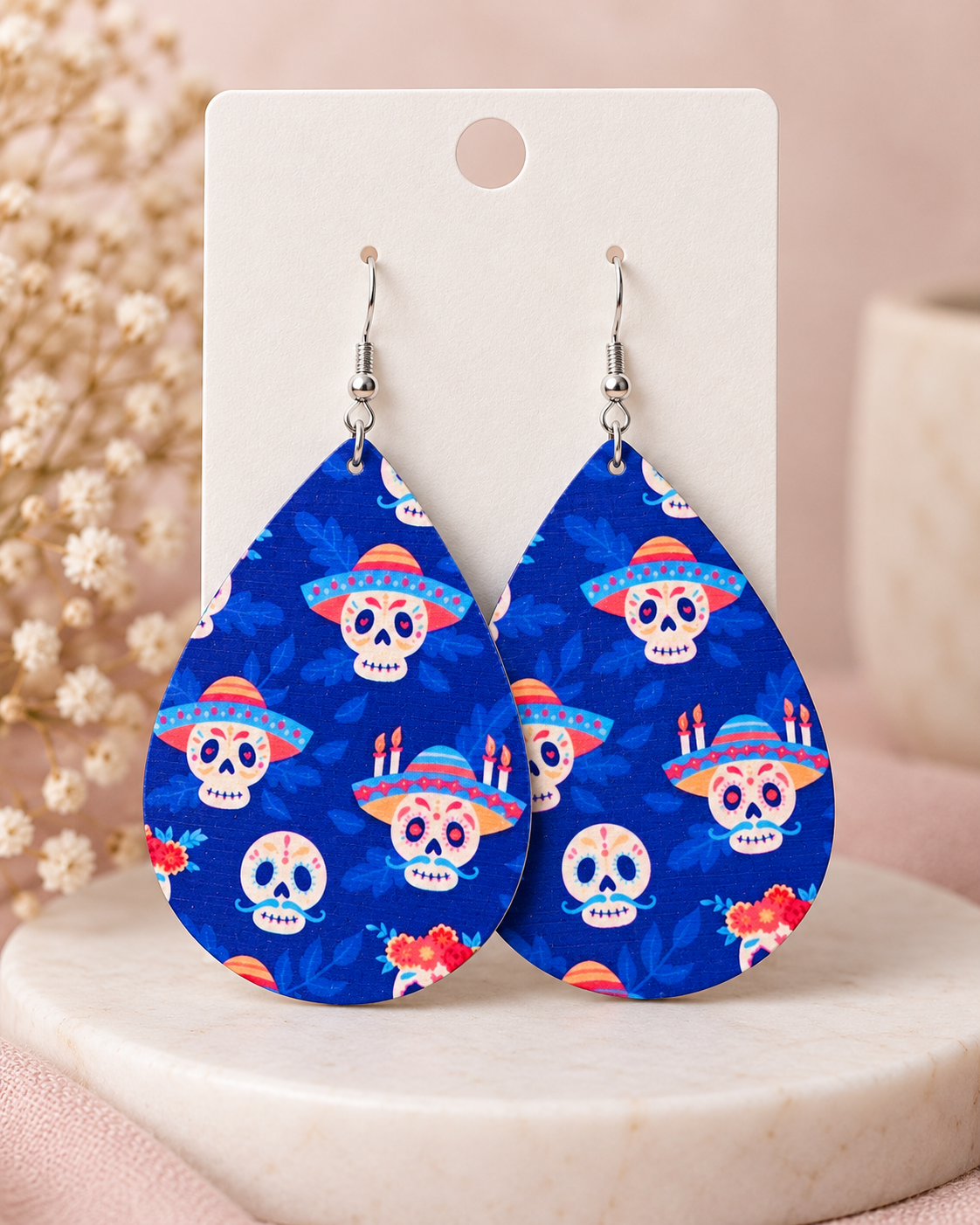 Fiesta Azul sugar skull earrings displayed on a neutral jewelry card with soft blush and cream styling