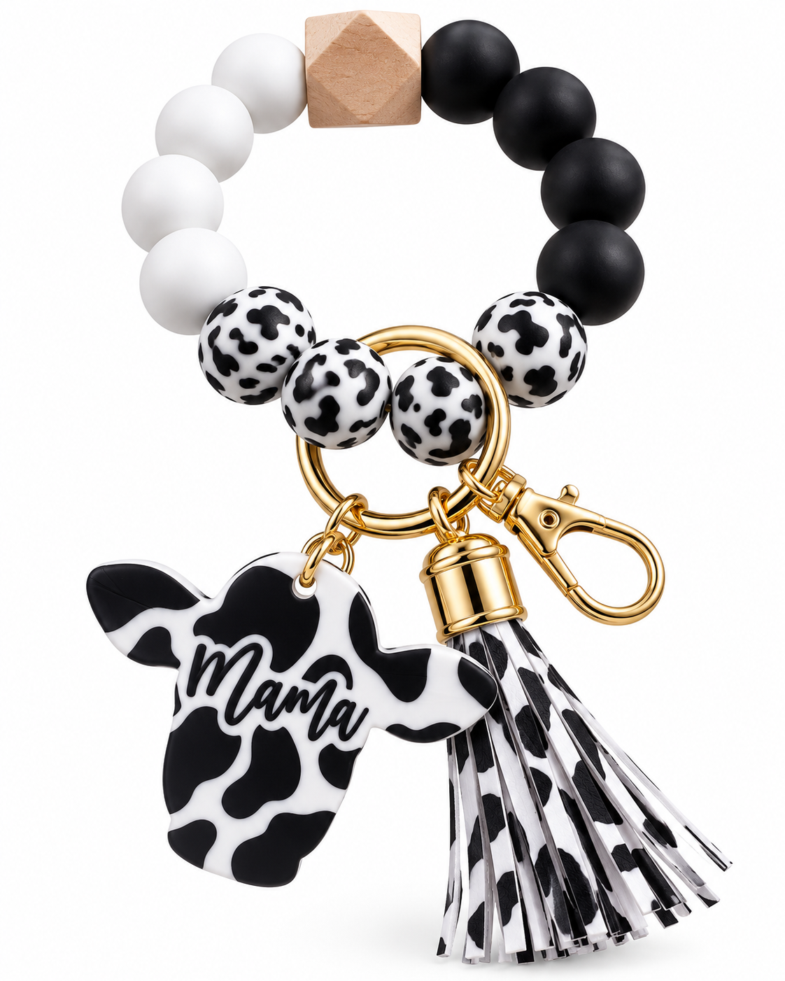 A beaded baby teether keychain featuring black and white beads, a natural wood cube, cow-print patterned beads, a gold-tone keyring, a black and white cow-print 'Mama' charm, and a matching tassel, shown on a white background.
