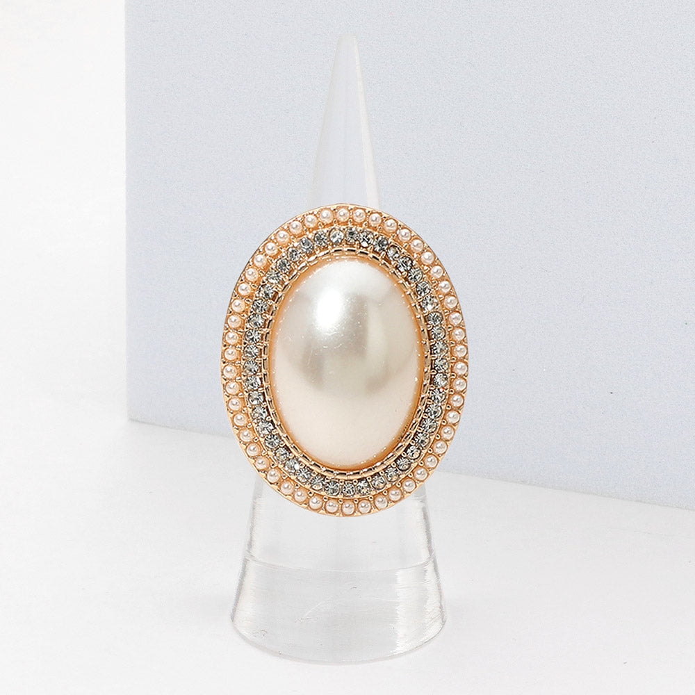 Decorative ring with pearl-like center and gold and silver accents on a white background