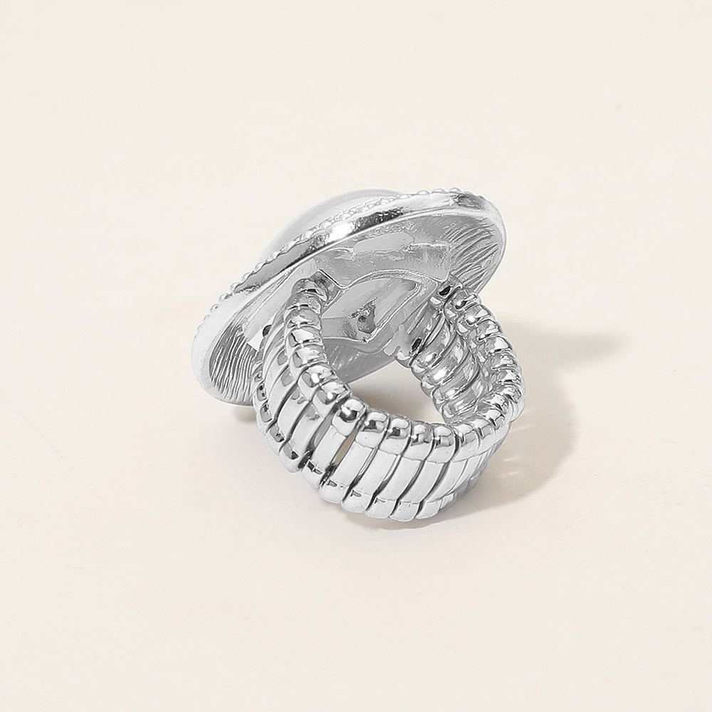 Silver ring with textured design on a light beige background