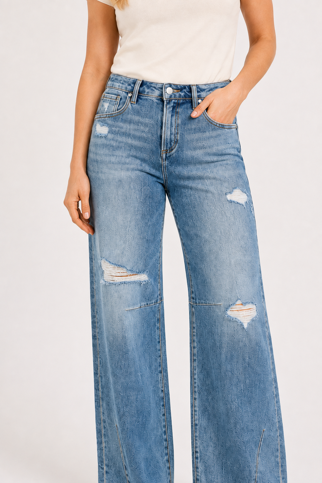 Close-up of RISEN tie-wash distressed wide-leg jeans with knee-panel seams