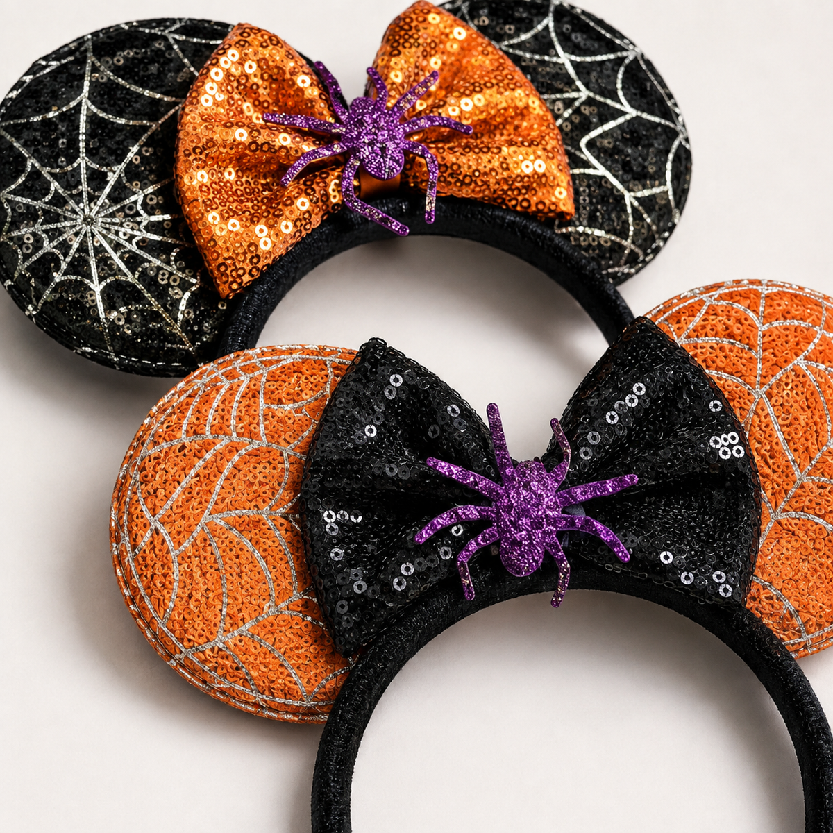 Close-up of Halloween spiderweb ear headbands with sequin bows and purple glitter spiders