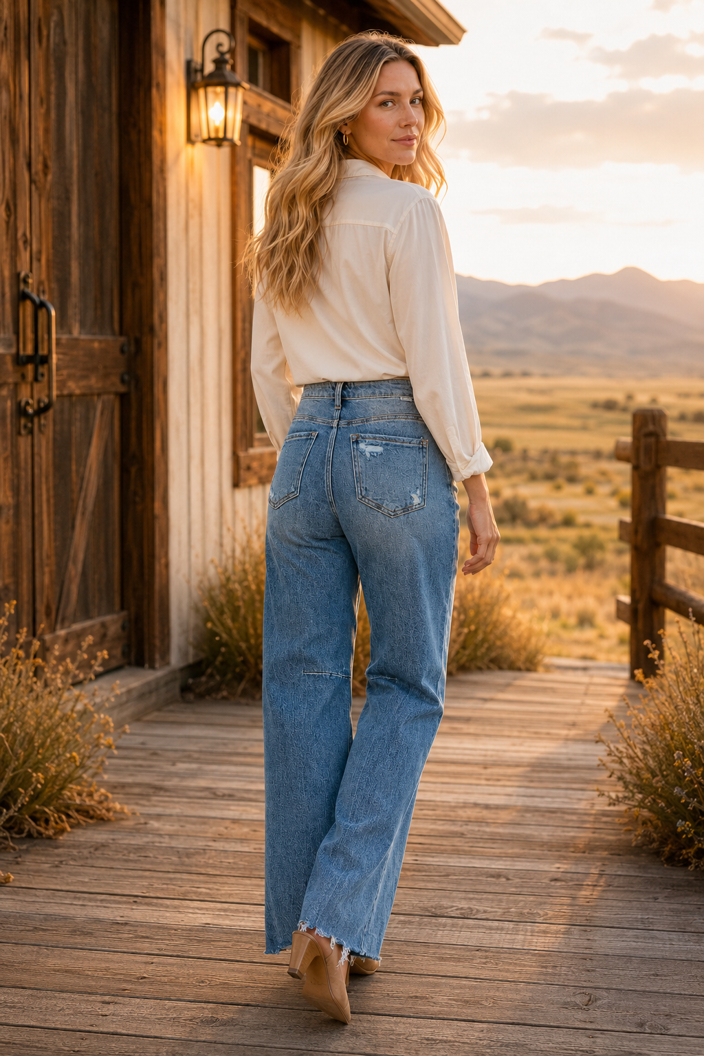 Back view of RISEN wide-leg jeans styled at a Wyoming ranch during sunset
