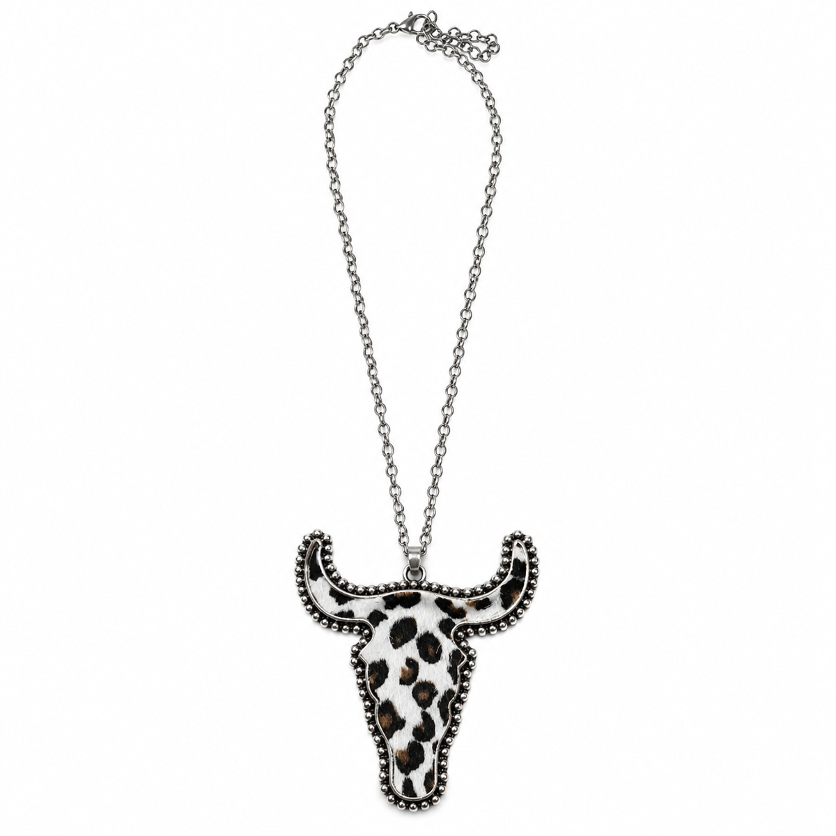 A silver-toned chain necklace featuring a bull skull pendant with a black and white leopard print pattern and silver beaded trim, shown against a plain white background.