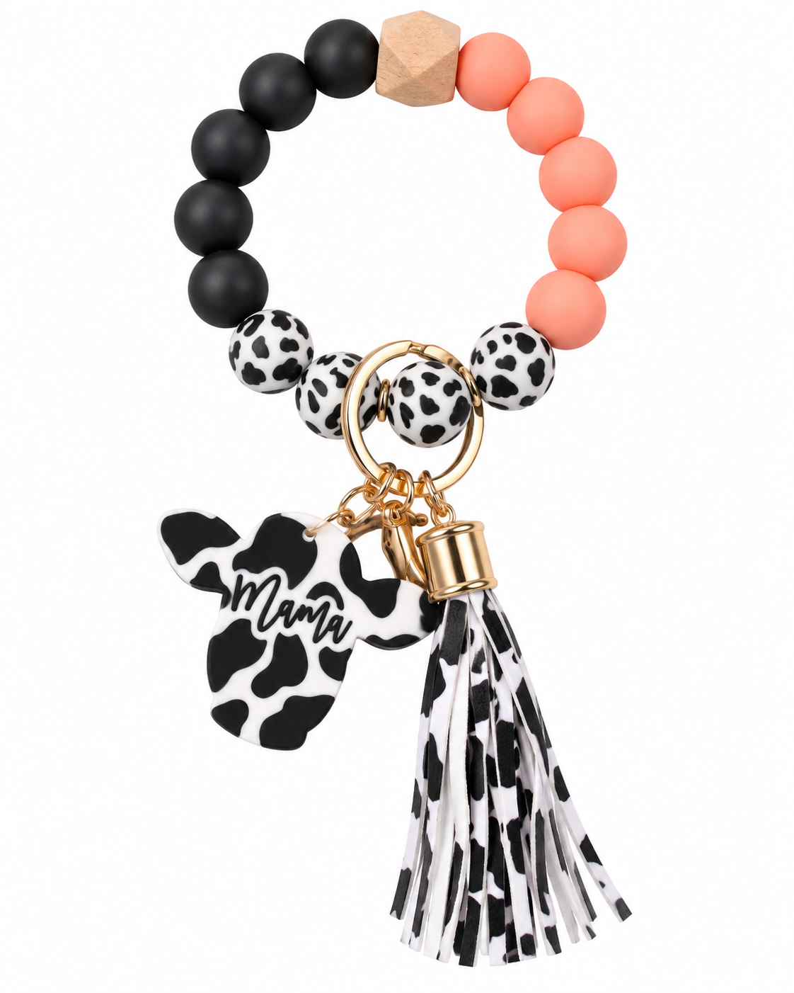 A beaded bracelet keychain featuring matte black, peach, and cow-print beads, a gold-tone key ring, a cow-print 'Mama' dog charm, and a black-and-white cow-print tassel, shown on a plain white background.