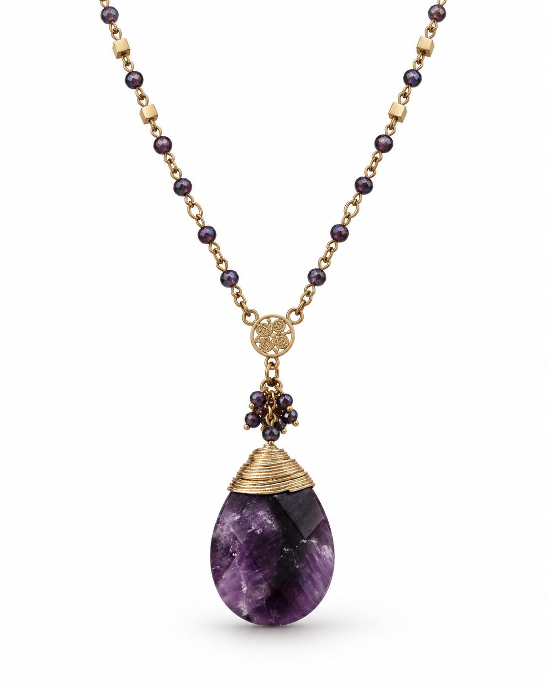 A gold-tone necklace featuring a teardrop-shaped purple amethyst pendant, a gold wire-wrapped cap, and a cluster of small dark purple beads, shown against a plain white background.