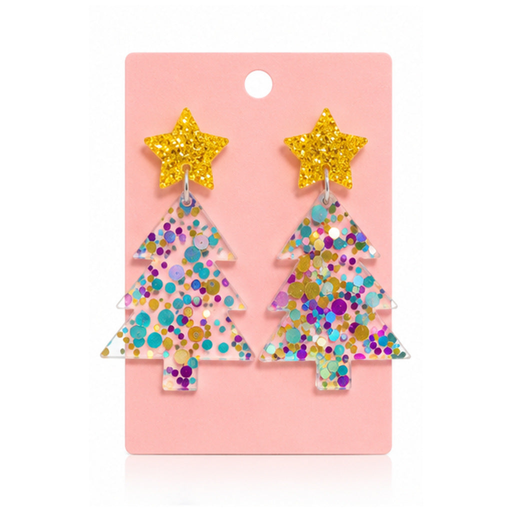 A pair of Christmas tree-shaped dangling earrings covered in multicolor glitter, each topped with a yellow glitter star, displayed on a pink backing card.