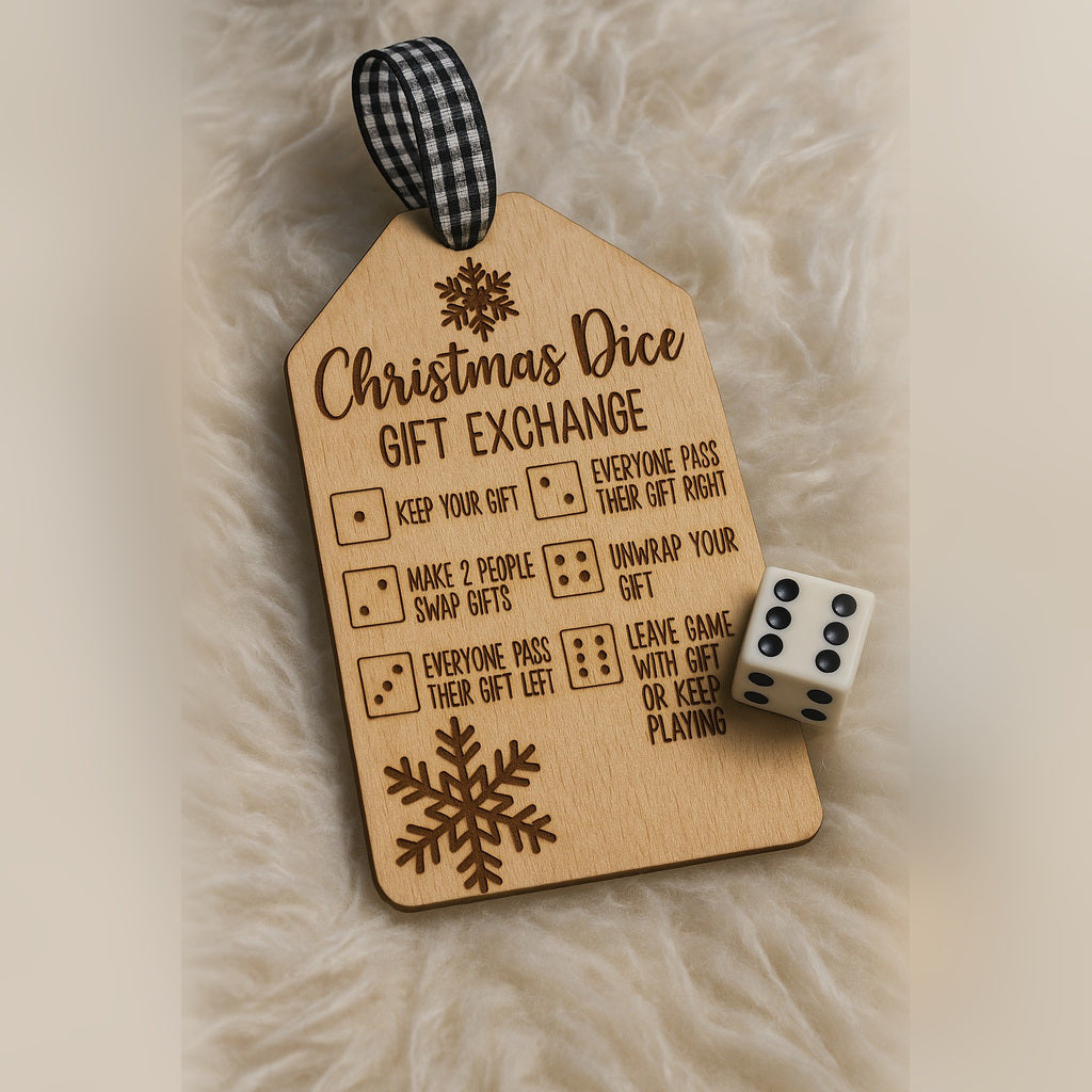 A wooden Christmas gift tag ornament engraved with 'Christmas Dice Gift Exchange' rules, featuring a black-and-white gingham loop at the top and a white die beside it, photographed on a soft white faux-fur surface.