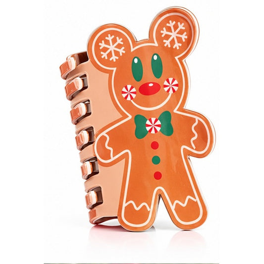 A spiral notebook with a gingerbread bear cover design, featuring white snowflakes, green eyes and bow tie, and red accents, set against a plain white background.