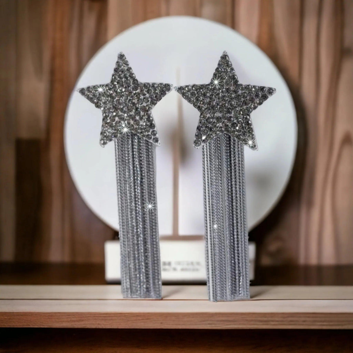 Star-shaped earrings with tassels on a wooden surface